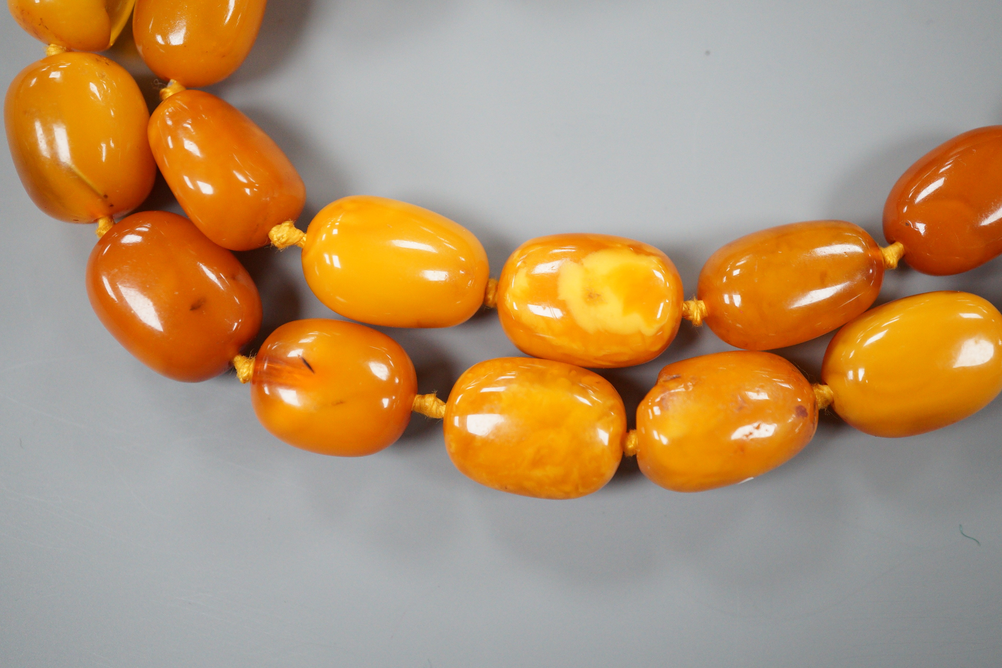 A single strand oval amber bead necklace, 90cm, gross 81 grams